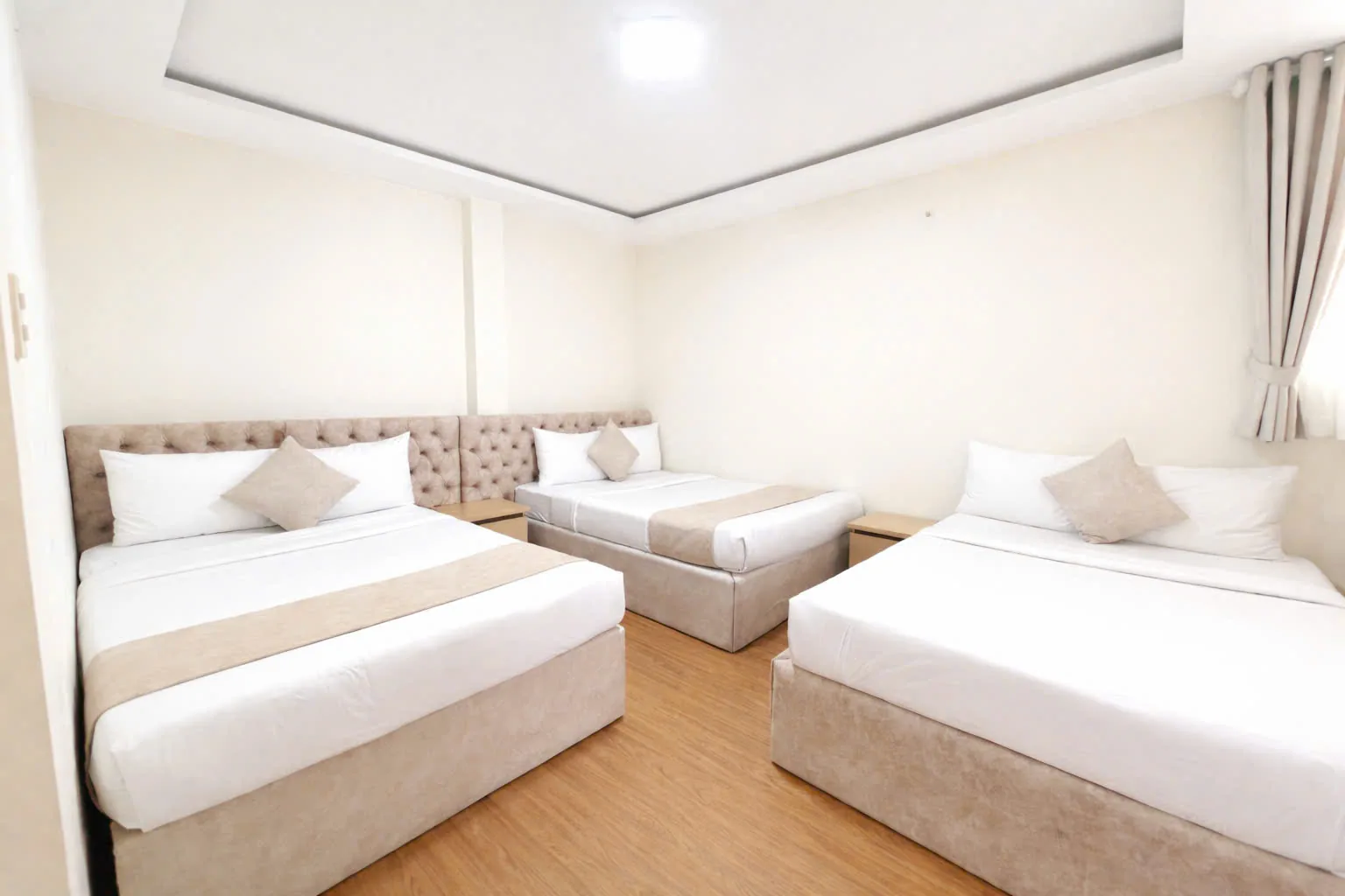 Giường lớn bọc nệm và giường phụ trong phòng Suite Family