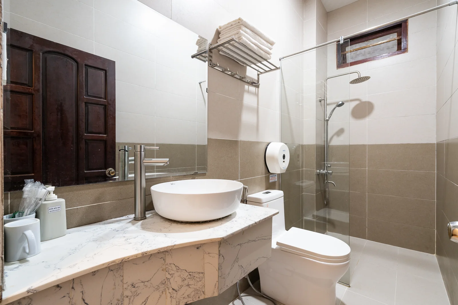 Phòng tắm với buồng sen kính và bồn rửa trong phòng Family khu Villa