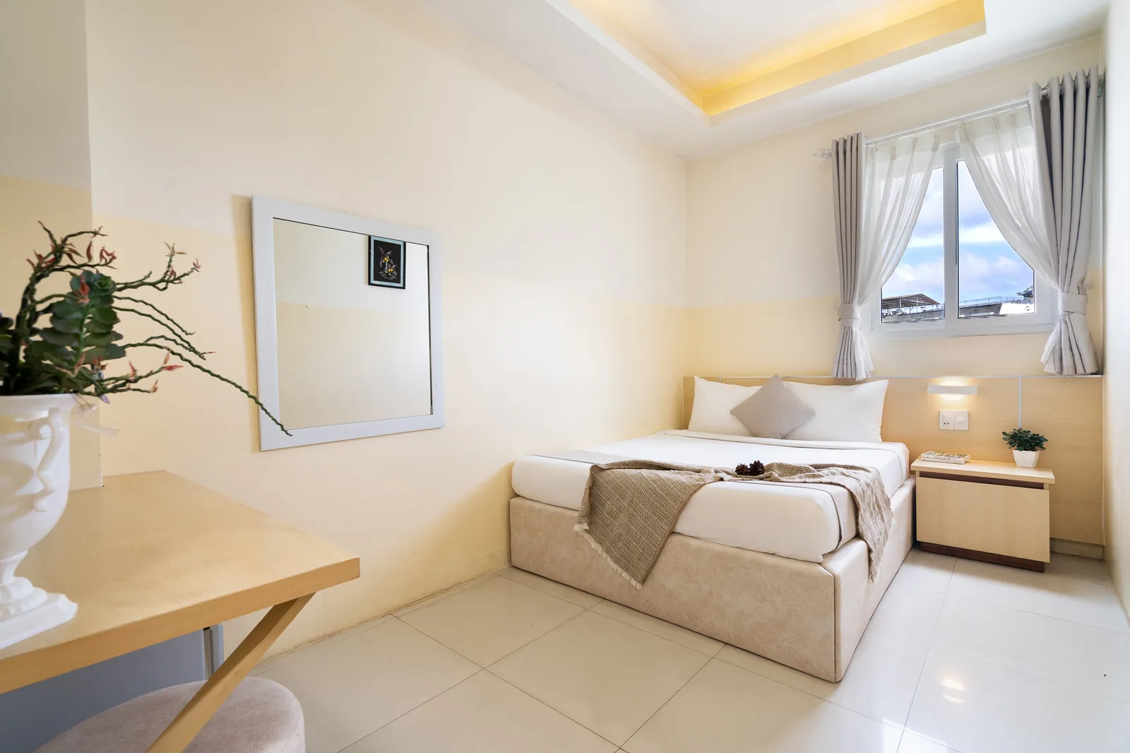 Góc bàn nhỏ, gương và giường 1.6m trong phòng Superior