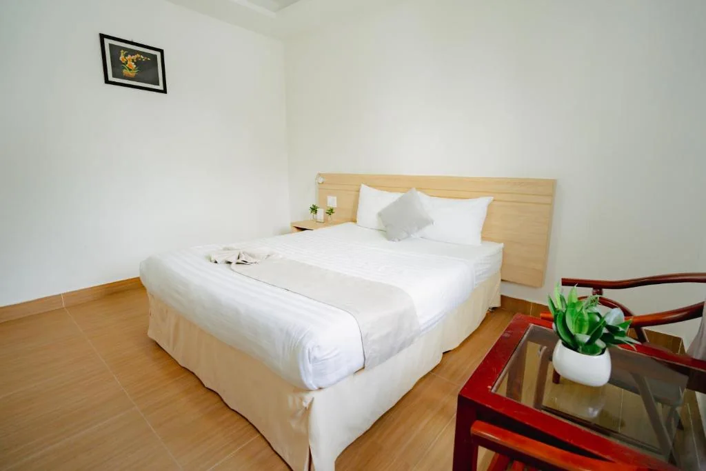 Giường 1.6m và bàn kính nhỏ trong phòng Superior khu Villa
