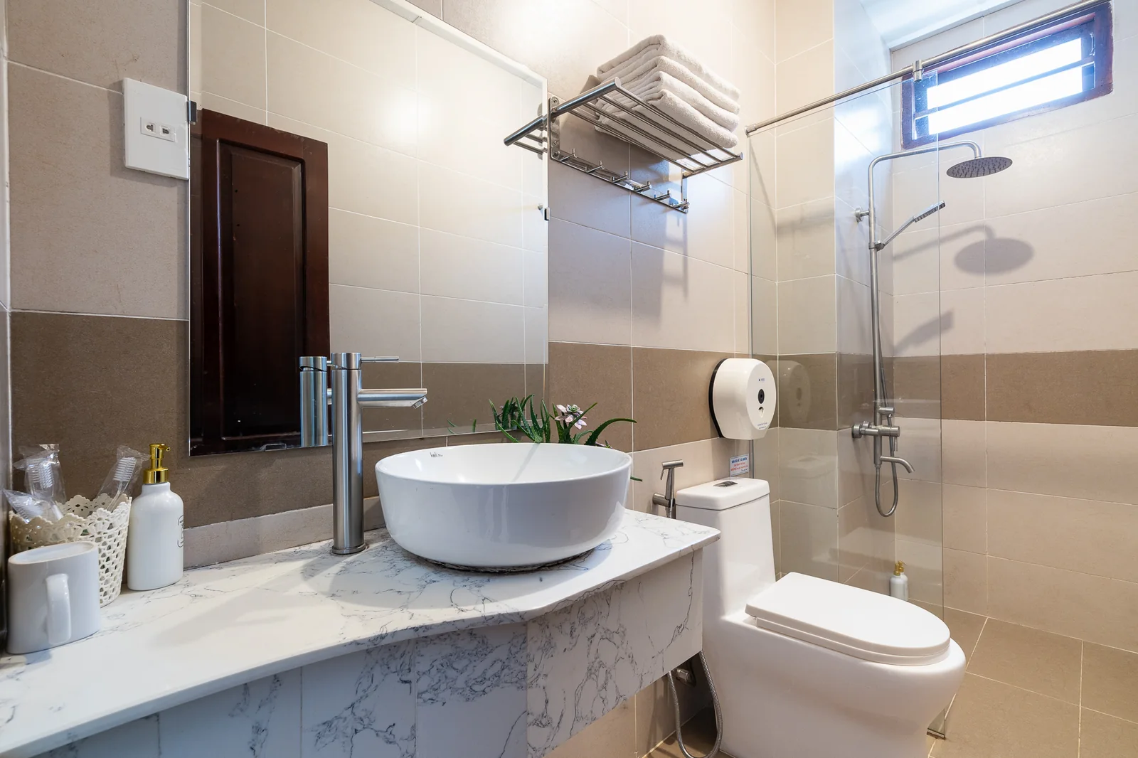 Phòng tắm với buồng sen kính và bồn rửa trong phòng Family View khu Villa
