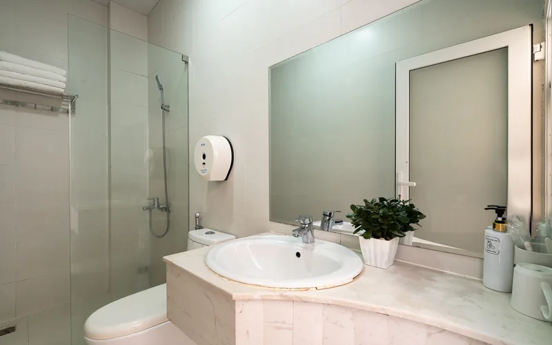 Phòng tắm khách sạn Ngọc Nguyên Anh với buồng sen kính và nước nóng 24/24